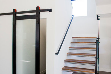 Ejemplo de escalera suspendida minimalista sin contrahuella con escalones de metal