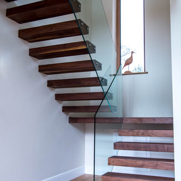 Floating treads staircase with frameless glass balustrade.