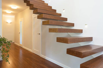 Idée de décoration pour un escalier sans contremarche flottant minimaliste de taille moyenne avec des marches en bois et éclairage.