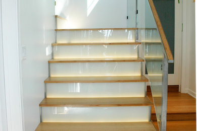 Imagen de escalera en L actual de tamaño medio con escalones de madera y contrahuellas de vidrio