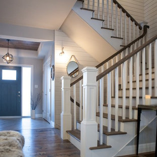 Immagine di un'ampia scala a "L" stile americano con pedata in legno e alzata in legno verniciato