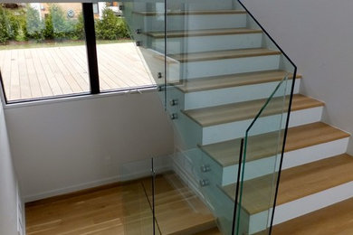 Ejemplo de escalera en U minimalista de tamaño medio con escalones de madera y contrahuellas de madera