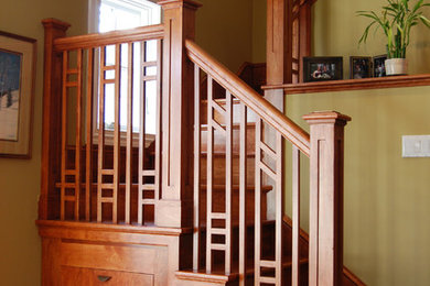 Ejemplo de escalera en U clásica de tamaño medio con escalones de madera y contrahuellas de madera