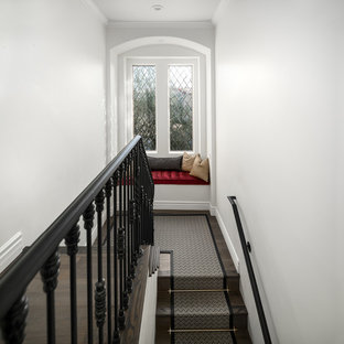 Immagine di un'ampia scala a rampa dritta shabby-chic style con pedata in moquette, alzata in legno e parapetto in metallo