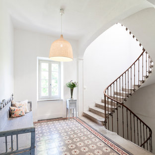 Cette image montre un grand escalier courbe méditerranéen avec des marches en béton et des contremarches en béton.