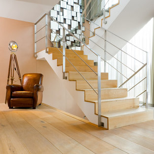 Cette image montre un grand escalier design en U avec des marches en bois et des contremarches en bois.