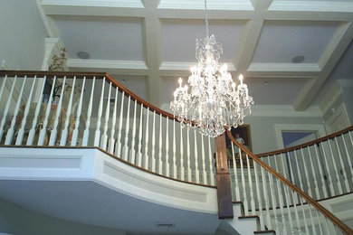 Staircase - large traditional wooden curved wood railing staircase idea in New York with painted risers
