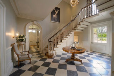 This is an example of a large traditional wood u-shaped staircase in Berkshire with wood risers.