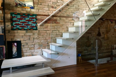 Example of a trendy wooden glass railing staircase design in Toronto