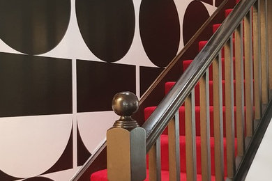 Imagen de escalera recta contemporánea de tamaño medio con escalones enmoquetados y barandilla de madera