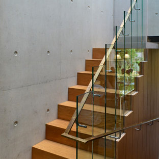 Photo of a medium sized modern wood u-shaped mixed railing staircase in London with wood risers.