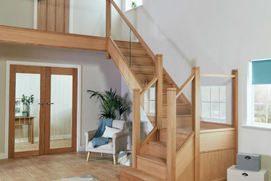 マンチェスターにある中くらいなトランジショナルスタイルのおしゃれな折り返し階段 (木の蹴込み板、ガラスフェンス) の写真