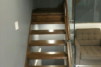 Example of a minimalist wooden open staircase design in New York