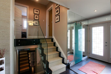 Example of a mid-sized minimalist wooden l-shaped glass railing staircase design in Toronto with wooden risers