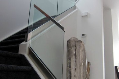 Example of a mid-sized minimalist carpeted u-shaped glass railing staircase design in Atlanta with carpeted risers