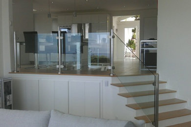 Imagen de escalera recta actual de tamaño medio con escalones de madera y contrahuellas de vidrio