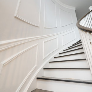 Ispirazione per una scala curva con pedata in legno, alzata in legno verniciato, parapetto in legno e boiserie