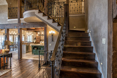 Foto de escalera en L rústica grande con escalones de madera, contrahuellas de madera y barandilla de metal