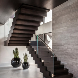Example of a large trendy wooden u-shaped glass railing staircase design in Miami with wooden risers