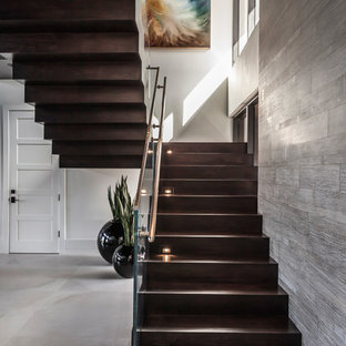 Idee per una grande scala sospesa design con pedata in legno, alzata in vetro e parapetto in metallo