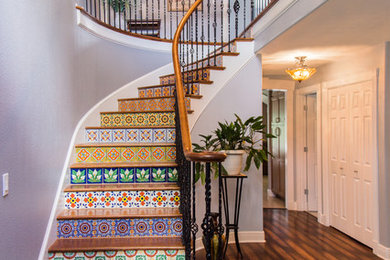 Example of a large tuscan wooden curved staircase design in Tampa with tile risers
