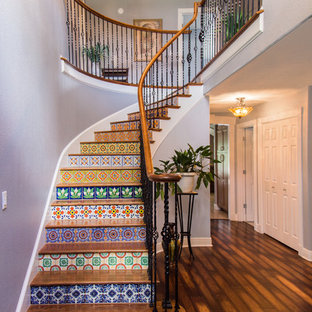Imagen de escalera curva, mediterránea, grande, con escalones de madera y contrahuellas con baldosas y/o azulejos