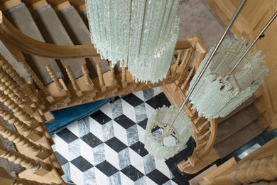 ロンドンにあるラグジュアリーな巨大なトラディショナルスタイルのおしゃれなサーキュラー階段 (木の蹴込み板) の写真