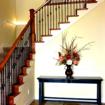 Grand wrought iron stair case with cherry rails