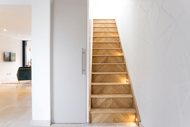Design ideas for a medium sized modern wood straight staircase in Surrey with wood risers.