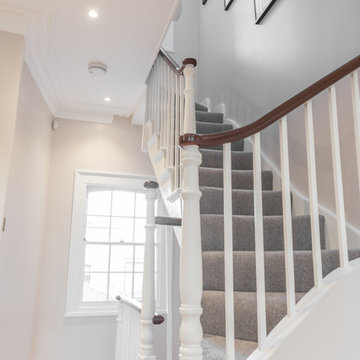 Grey carpeted staircase with traditional detailing