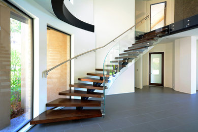 Example of a minimalist wooden floating open staircase design in Los Angeles
