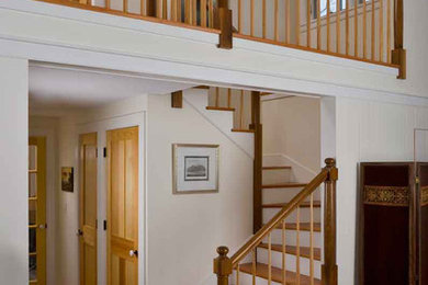 Exempel på en mellanstor klassisk svängd trappa i trä, med sättsteg i målat trä och räcke i trä