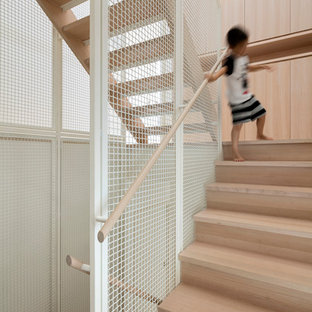 Photo of a scandinavian wood u-shaped staircase in Melbourne with wood risers.