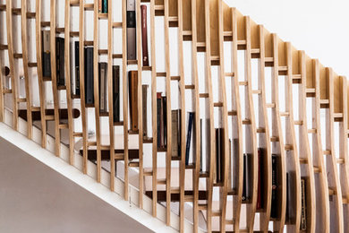 Imagen de escalera recta actual grande sin contrahuella con escalones de madera y barandilla de madera