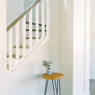Staircase - mid-sized cottage wooden u-shaped wood railing staircase idea in Calgary with painted risers