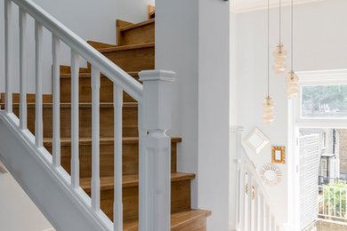 This is an example of a medium sized contemporary wood curved wood railing staircase in London with wood risers.