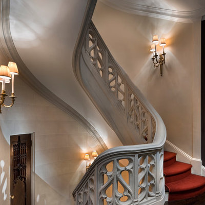 Example of a huge classic carpeted spiral staircase design in New York with wooden risers