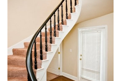Mid-sized elegant carpeted curved staircase photo in DC Metro with wooden risers