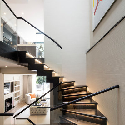 Inspiration for a mid-sized contemporary wooden u-shaped glass railing staircase remodel in London with wooden risers