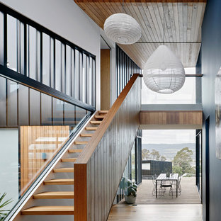 Inspiration for a large modern wood straight staircase in Melbourne with open risers and wood railing.