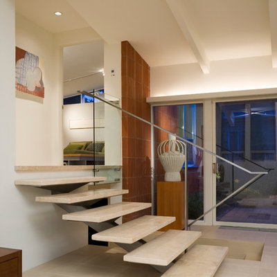 Example of a minimalist travertine open and metal railing staircase design in Denver