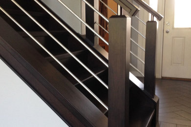 Imagen de escalera recta moderna de tamaño medio con escalones de madera, contrahuellas de madera y barandilla de madera
