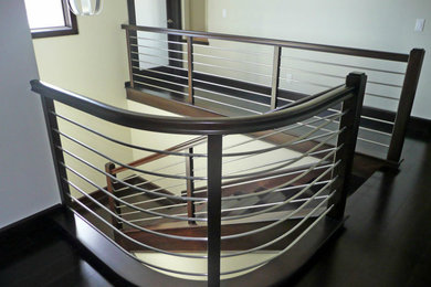 Imagen de escalera en U contemporánea con escalones de madera, contrahuellas de madera y barandilla de madera