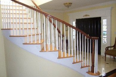 Mid-sized elegant wooden curved staircase photo in New York with wooden risers