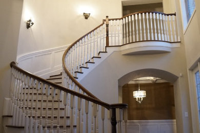 Example of a large classic wooden curved staircase design in Other with painted risers