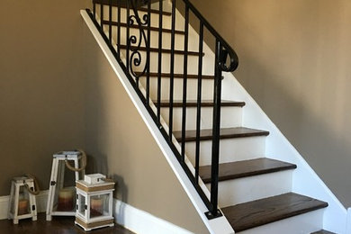 Diseño de escalera recta tradicional renovada de tamaño medio con escalones de madera, contrahuellas de madera pintada y barandilla de metal