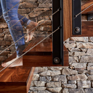 Immagine di una scala sospesa moderna di medie dimensioni con pedata in legno e parapetto in cavi
