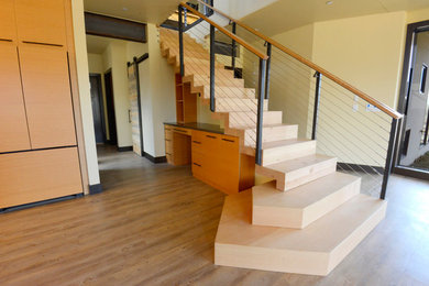 Diseño de escalera recta minimalista grande con escalones de madera, contrahuellas de madera y barandilla de cable