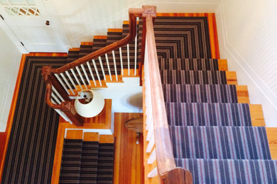 Photo of a carpeted l-shaped staircase in Boston with carpeted risers.