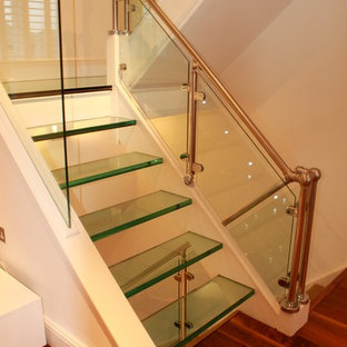 Ejemplo de escalera suspendida, actual, grande, sin contrahuella, con escalones de vidrio